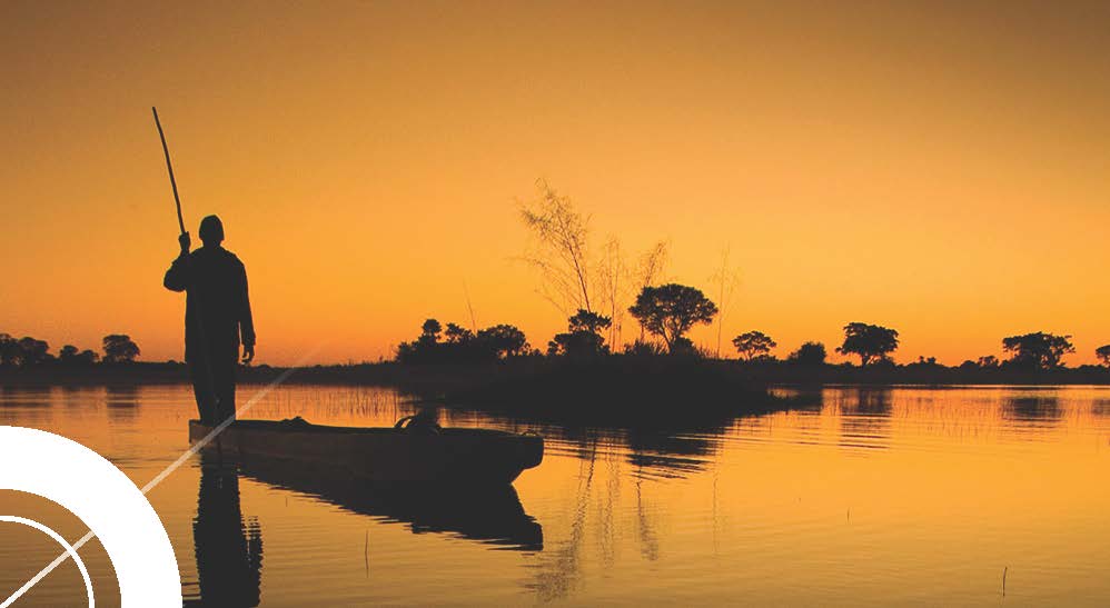 Fotografia de um pescador com pôr do sol laranja, em Angola